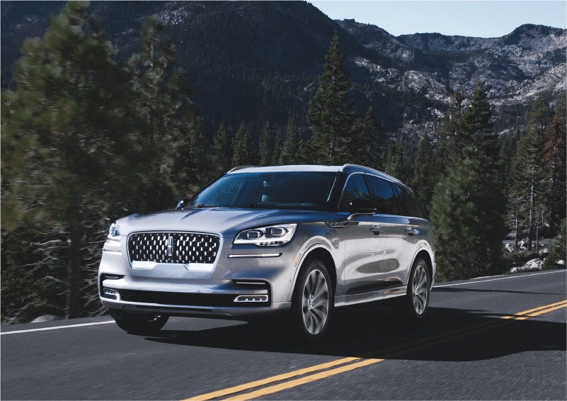 A 2023 Lincoln Aviator® Grand Touring SUV being driven on a winding road to demonstrate the capabilities of all-wheel drive | Purchase Lincoln in Mayfield KY