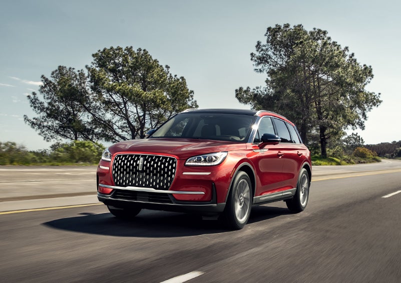 A 2024 Lincoln Corsair® SUV is shown being driven on a country road. | Purchase Lincoln in Mayfield KY