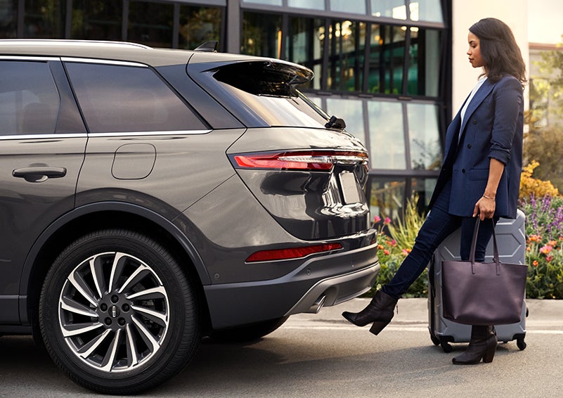 A woman with her hands full uses her foot to activate the available hands-free liftgate. | Purchase Lincoln in Mayfield KY