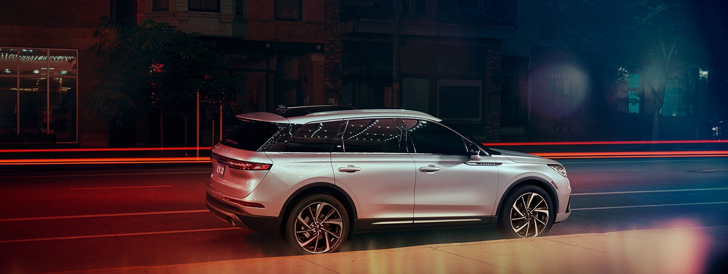 The 2024 Lincoln Corsair® SUV is parked on a city street at night. | Purchase Lincoln in Mayfield KY